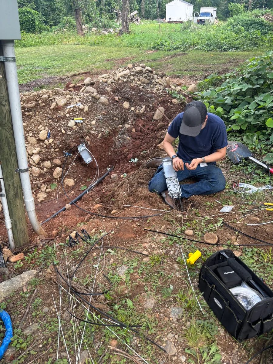 CMV technician splicing fiber at an open pit